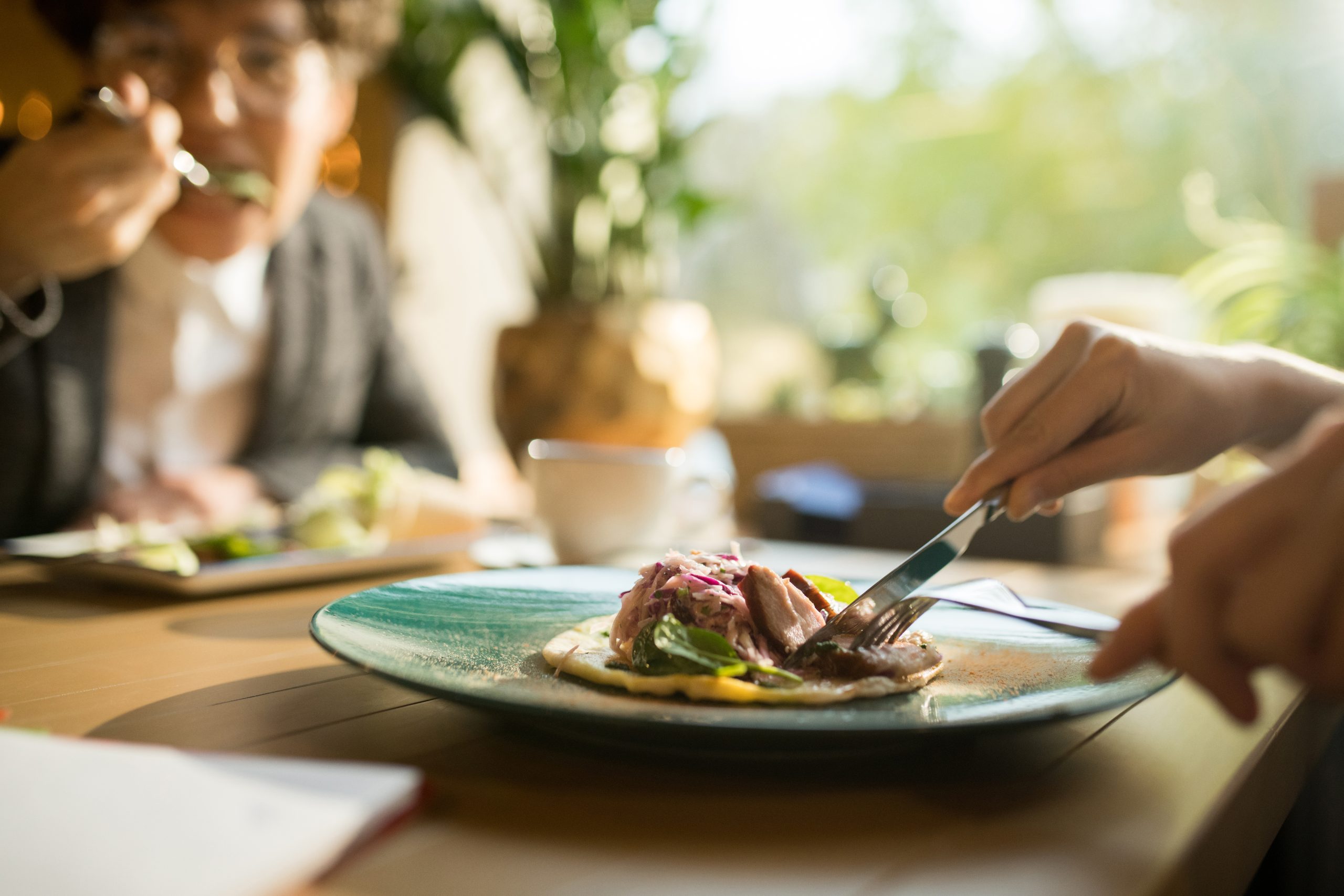 Cutting meat slice while eating delicious dish