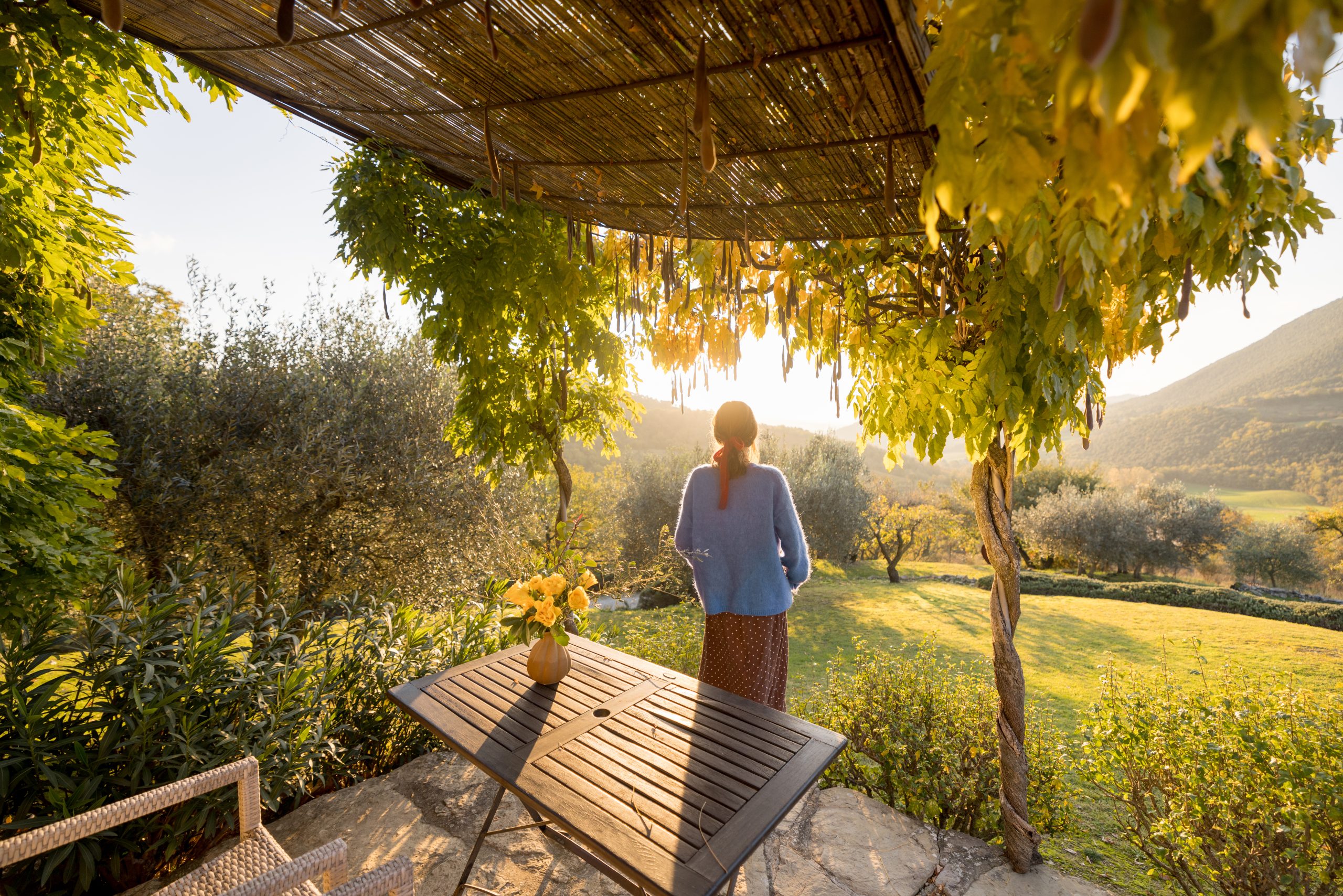 Woman Under Sunlit Pergola